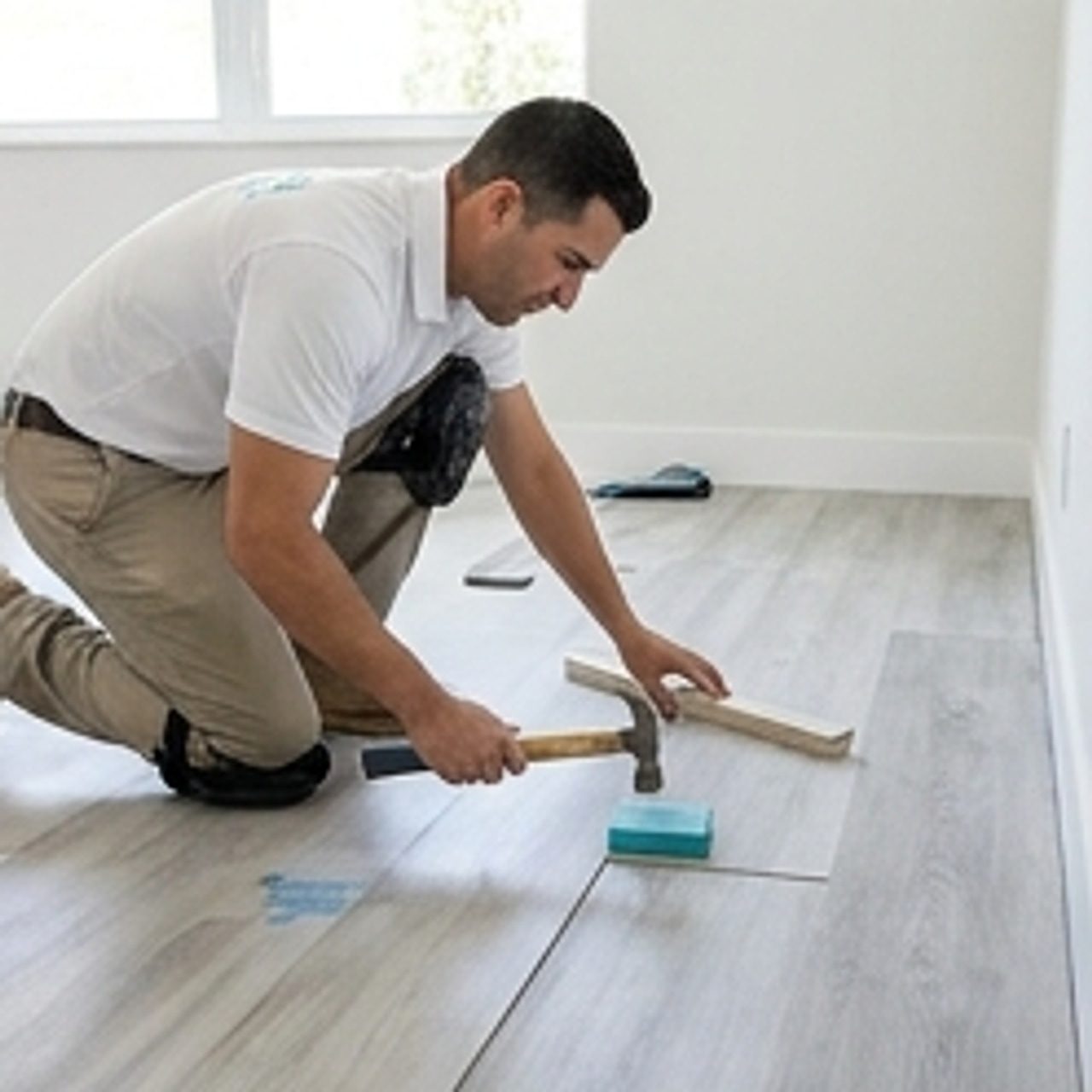 worker laying down vinyl flooring